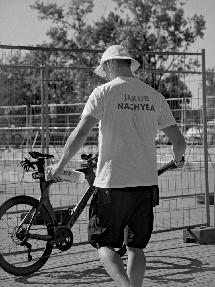 Jakub Nachyła prowadzi rower czasowy, na plecach napis Jakub Nachyła